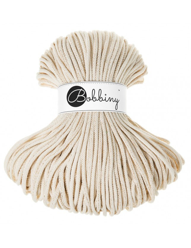 Angled view of Bobbiny golden natural cotton braided cord skein