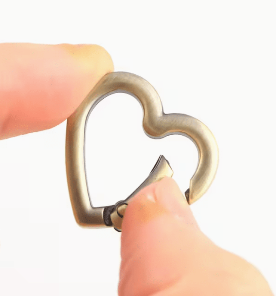 Antique brass heart-shaped metal carabiner clip with spring-loaded gate mechanism