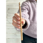 Beech wood crochet hook held in hand, in use