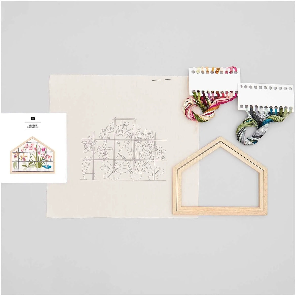 Embroidery kit contents including pre-printed cotton fabric, threads, and wooden frame