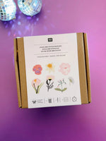 Top view of closed Rico Design embroidery kit box on purple background