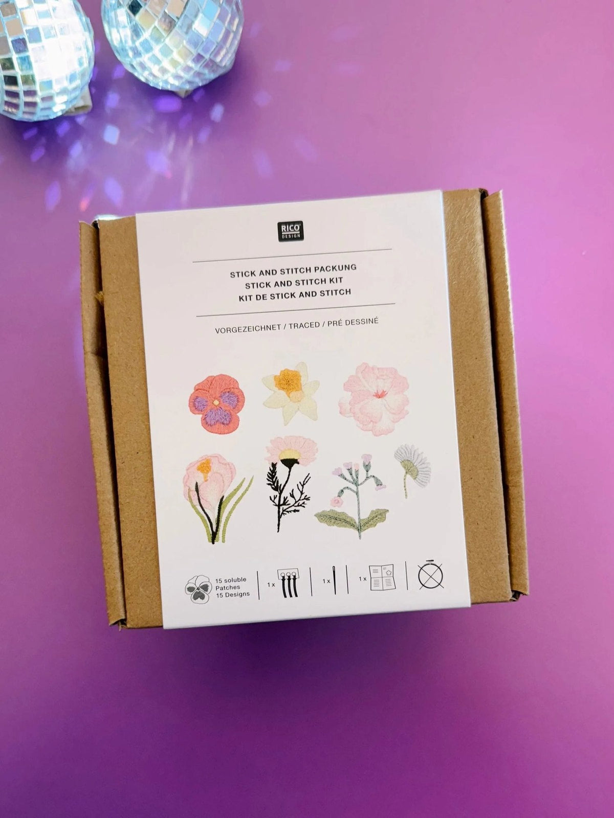 Top view of closed Rico Design embroidery kit box on purple background