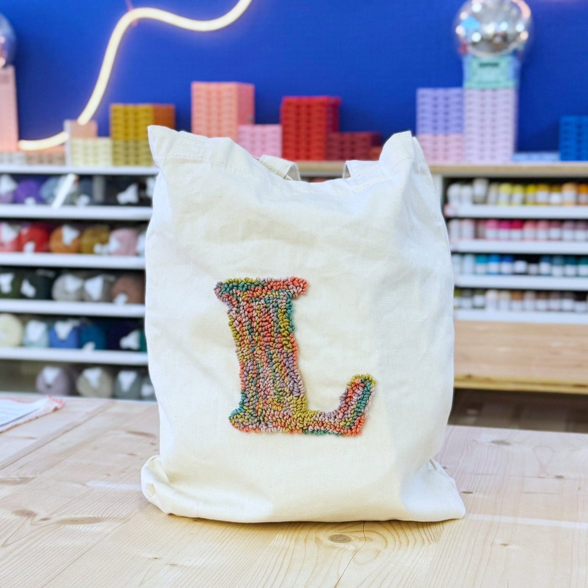 Organic cotton tote bag with multicolored punch needle letter L design