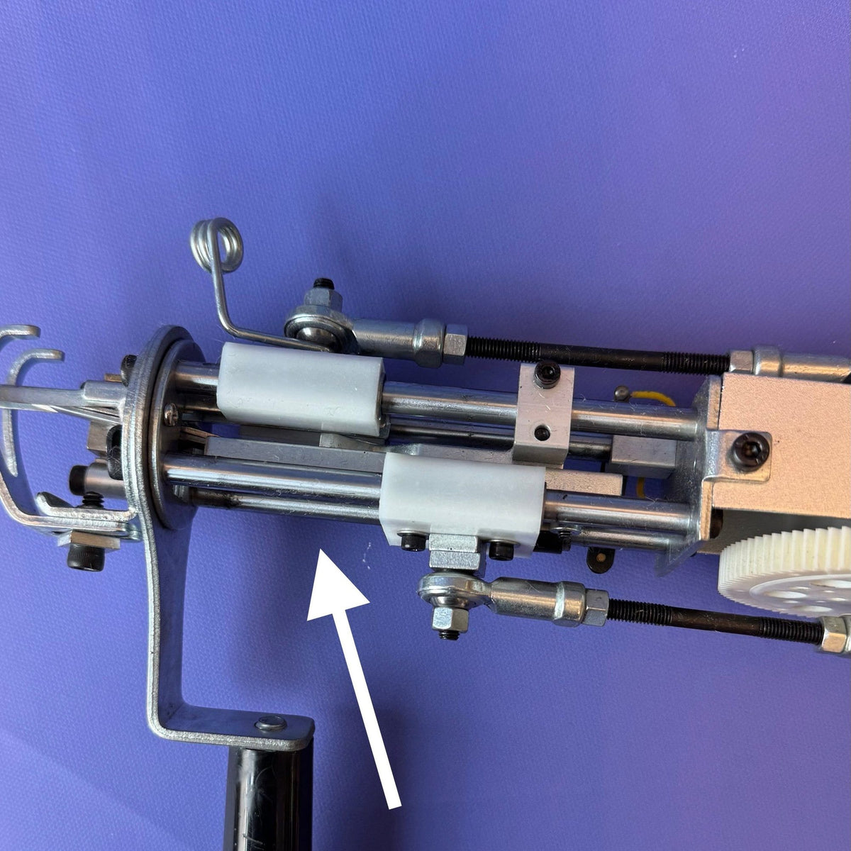 Close-up of silver metal main rod assembly for AK series tufting machine