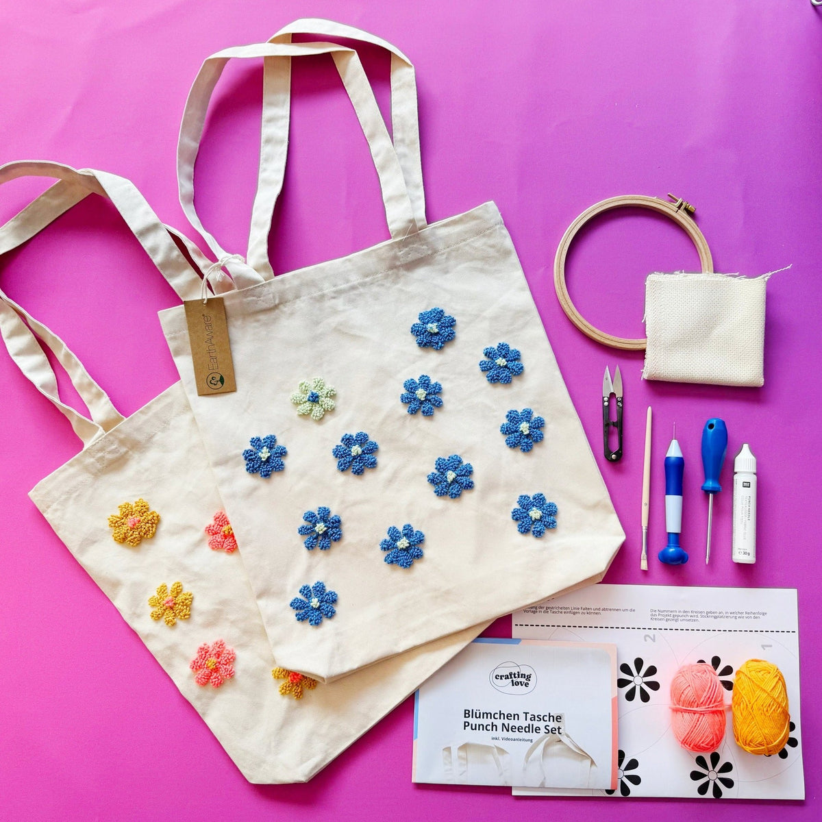 Beige tote bags with blue and yellow punch needle flowers alongside full kit contents
