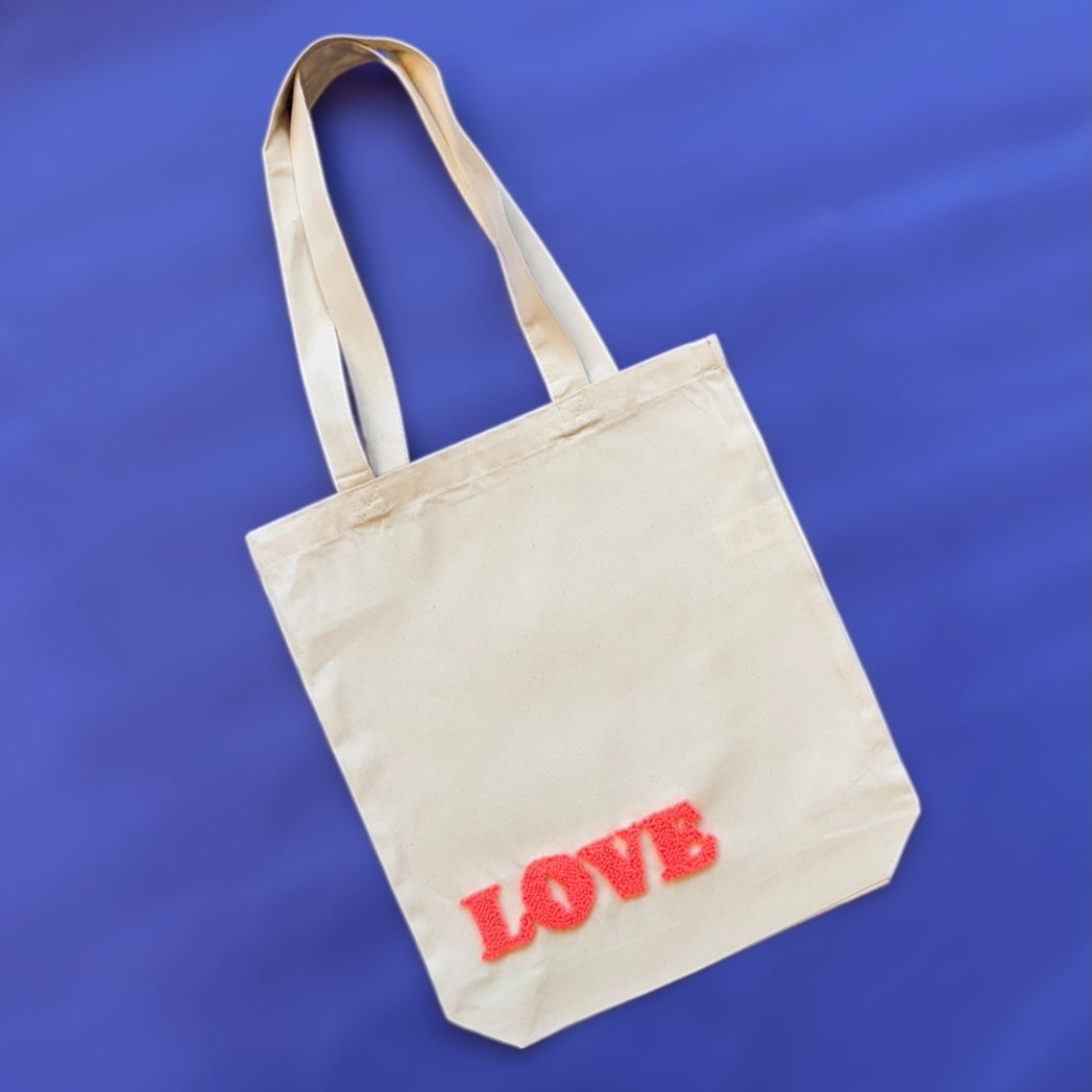 Love pattern punch needle bag with red yarn stitched on cream canvas