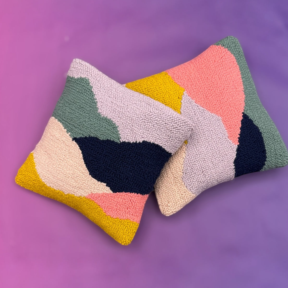 Set of two textured looped punch needle pillows in mustard, navy, and coral pink