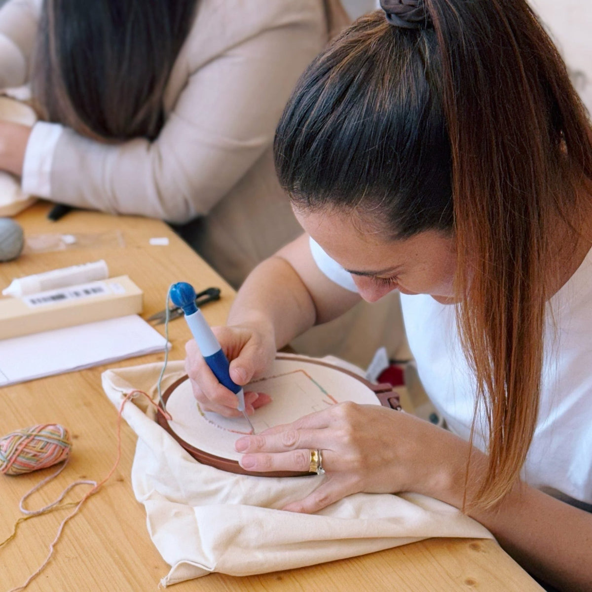 Student using punch needle tool at workshop