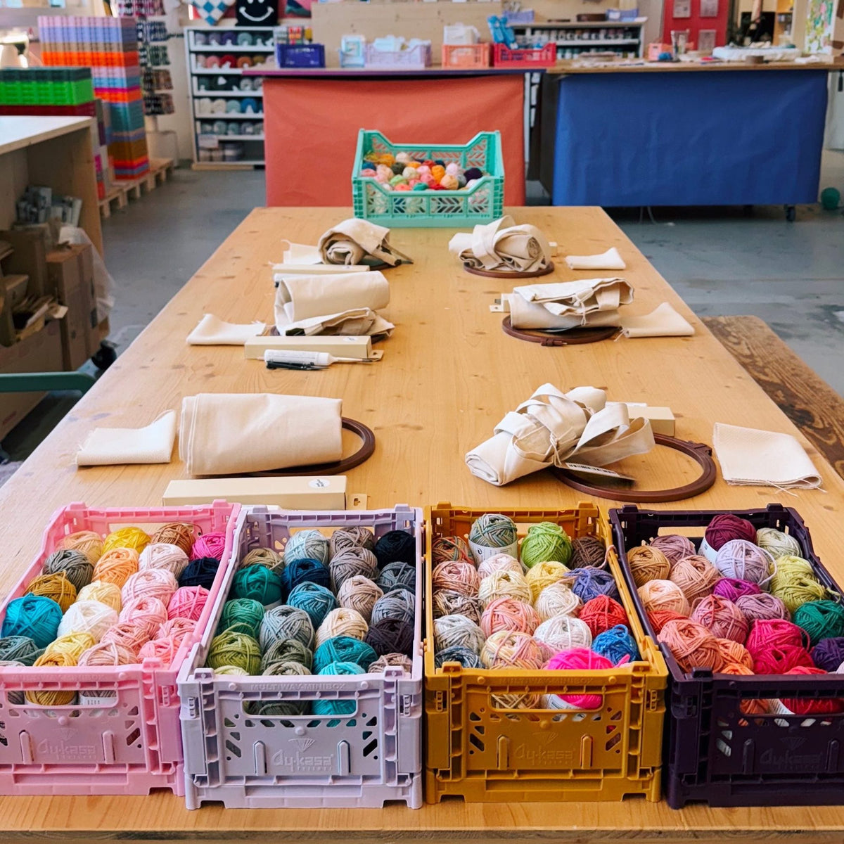 Workshop table setup with yarn and fabric supplies
