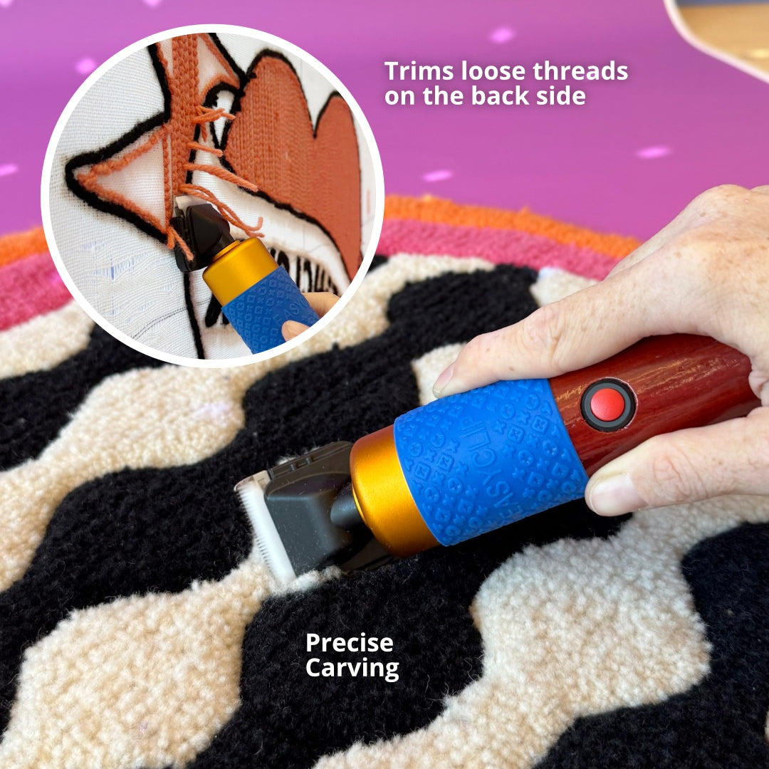 Hand using tufting clipper to trim loose threads from black and cream rug